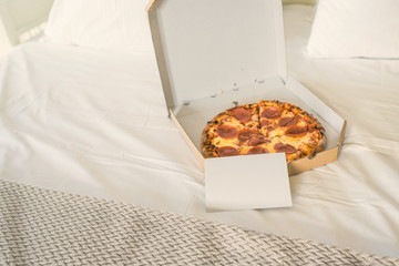 Wall Mural - Open box of pizza on the big bed with empty card for text. Concept