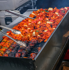 Wall Mural - Grilling Chicken Skewers at a Jamaican Food Stand in a Night Market