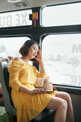 Wall Mural - Young woman using tablet computer on the bus