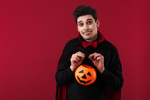 Image Of Nice Vampire Man In Halloween Costume Holding Pumpkin Lamp