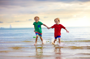 Wall Mural - Kids play on tropical beach. Sand and water toy.