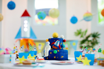 Kids space theme birthday party with cake.