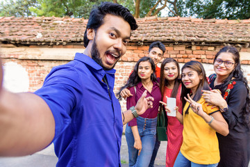 Best friends multiracial people taking selfie outdoor - Happy friendship concept with young students having fun together