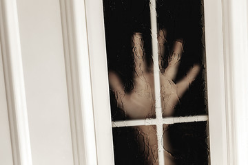 Palm of child in door window. Loneliness or safety concept