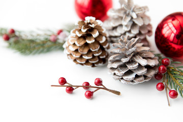 winter holidays, new year and decorations concept - red christmas balls and fir branches with pine c