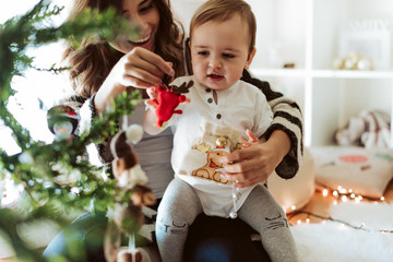 Wall Mural - mother and baby playing around the christmas tree