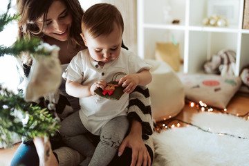 Wall Mural - mother and baby playing around the christmas tree