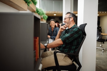 handsome stylish entrepreneur interacting and working in modern coworking office workspace