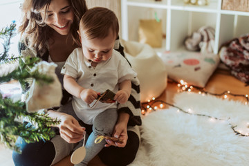 Wall Mural - mother and baby playing around the christmas tree