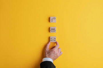 Sticker - Placing three wooden blocks with contact and communication icons on them on a bright yellow background