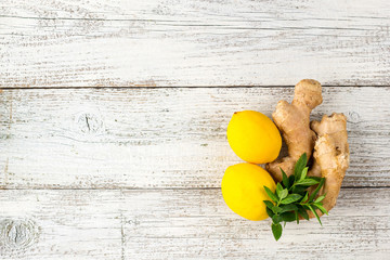 Wall Mural - fresh ginger lemon and mint on white wooden background