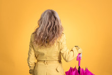 Woman From Behind With Umbrella And Raincoat Isolated On Color Background