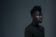 © Carlos David - Portrait of a young man looking at camera on dark black studio background