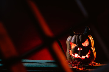 Scary Halloween pumpkins on wood in a spooky place at night. Poster concept.