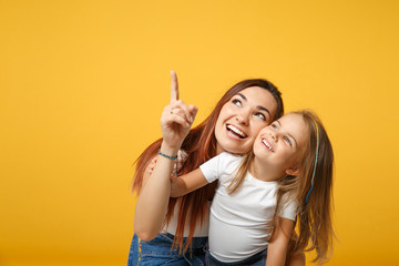 Woman in light clothes have fun with cute child baby girl 4-5 years old. Mommy little kid daughter isolated on yellow background studio portrait. Mother's Day love family parenthood childhood concept.