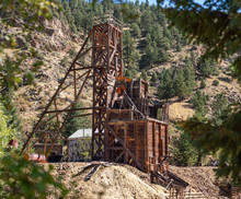 An Old Gold Mine Structure On The Side Of A Mountain Road With A Pile Of Overburden Around It.