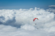 Paraglider silhouett against a cloudy blue sky.