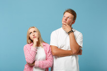 Young Pensive Couple Two Friends Guy Girl In White Pink Blank Empty Design T-shirts Posing Isolated On Pastel Blue Background. People Lifestyle Concept. Mock Up Copy Space. Put Hands Prop Up On Chins.
