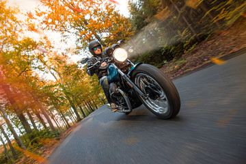 Wall Mural - Moto racer riding on mountain road during sunset, blurred motion travel to Europe.