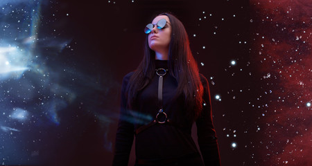 Wall Mural - portrait of mysterious sensual beautiful brunette woman in futuristic black dress on dark space magi