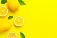 Creative Background With Fresh Lemons And Green Leaves On Bright Yellow Background. Top View Flat Lay Copy Space. Lemon Fruit Citrus Minimal Concept Vitamin C. Composition With Whole, Slices Of Lemons