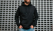© San4ezz007 - City portrait of handsome hipster guy with beard wearing black blank hoodie or sweatshirt and hat with space for your logo or design. Mockup for print