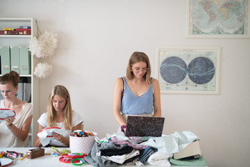 Wall Mural - woman using laptop at embroidery class