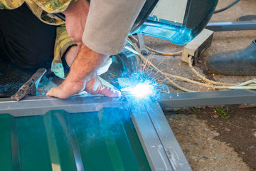 hands of men engaged in metal welding