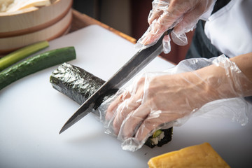 Poster - sushi chef making roll sushi with cucumber and egg