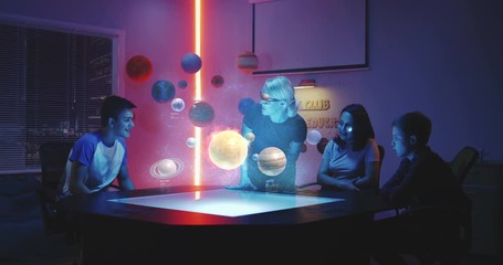 Wall Mural - Teacher giving a class with holographic solar system