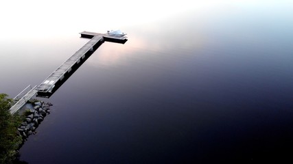 Canvas Print - Aerial shot of a boat near a dock on an empty sea