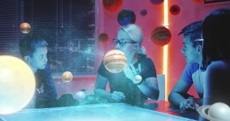 Wall Mural - Teacher giving a class with holographic solar system