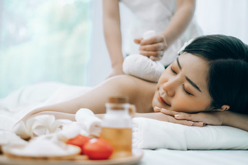 Beautiful young woman lying down on beds massage and spa at asian spa massage and beauty salon center, spa concept, massage concept