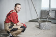 © Kadmy - Floor cement work. Professional Plasterer portrait during smoothing floor surface