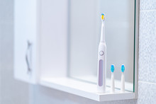 Ultrasonic Electric Toothbrush With Interchangeable Nozzles In Bathroom At Home. Oral Hygiene, Dental And Gum Health, Healthy Teeth. Dental Products