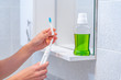 © Goffkein - Ultrasonic electric toothbrush with interchangeable nozzles and mouthwash for fresh breath in bathroom at home. Oral hygiene, dental and gum health, healthy teeth. Dental products