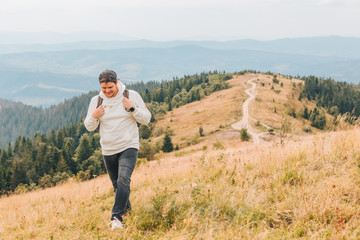 Wall Mural - man with backpack hiking by autumn mountains