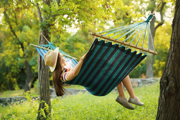 Poster - Young woman resting in comfortable hammock at green garden