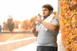 © New Africa - Young overweight man with towel and bottle of water in park