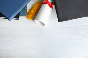 Wall Mural - Flat lay composition with graduation hat and student's diploma on white wooden table, space for text