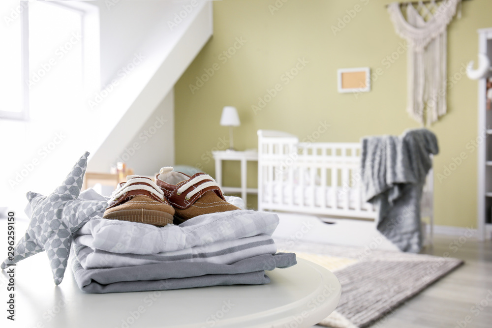 Stack of clean clothes on table in children's room