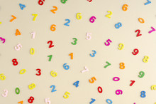 Colored Wooden Numbers Composition On Beige Background.