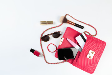 Fashion concept : Flat lay of purple leather woman bag open out with sunglasses and smartphone on white background. - Image