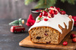 Christmas cake with cranberries and Christmas decorations on a dark background.