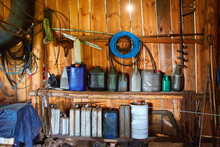 A Group Of Old Canisters And Cylinders Stand On Shelves In A Wooden Shed