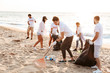 © Drobot Dean - Image of young voluntary workers cleaning beach from plastic at seashore