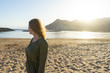 © Baifoworld - Spiritual adolescent in green dress admire the sunset and the sea town on a hill in Tenerife. Blonde romantic woman look the paradise in her vacation in calm