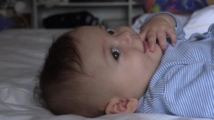 Wall Mural - adorable baby in bed looking and observing portrait