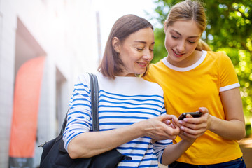 Wall Mural - mother showing daughter mobile phone