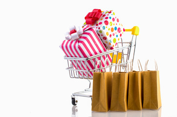 Many boxes in a trolley on a laptop keyboard,on brick background. Ideas online shopping is a form of electronic commerce that allows consumers to directly buy goods from a seller over the internet.